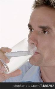 Close-up of a mid adult man drinking a glass of water