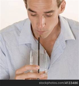 Close-up of a mid adult man drinking with a straw