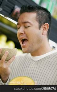 Close-up of a mid adult man eating a cantaloupe