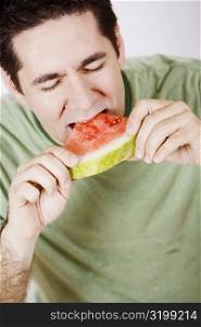 Close-up of a mid adult man eating a slice of watermelon