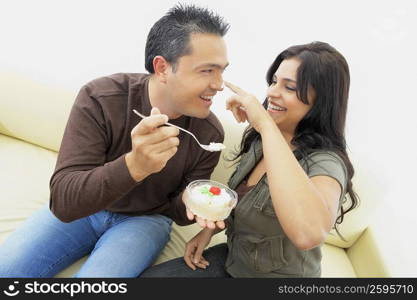 Close-up of a mid adult man feeding a young woman