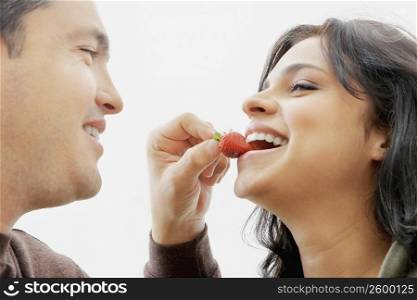 Close-up of a mid adult man feeding a young woman