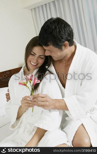 Close-up of a mid adult man giving flowers to a young woman