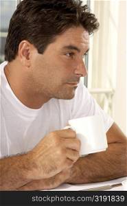 Close-up of a mid adult man holding a cup of coffee