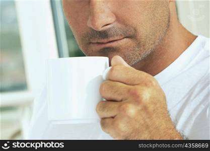 Close-up of a mid adult man holding a cup of coffee