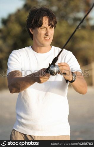 Close-up of a mid adult man holding a fishing rod