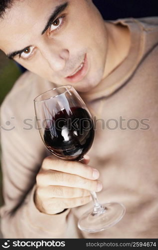 Close-up of a mid adult man holding a glass of red wine