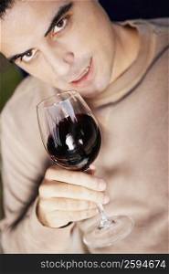 Close-up of a mid adult man holding a glass of red wine