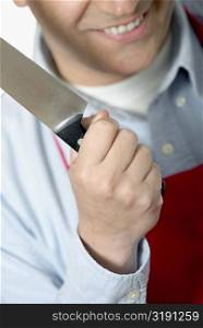 Close-up of a mid adult man holding a kitchen knife