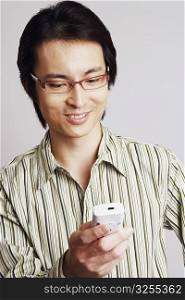 Close-up of a mid adult man holding a mobile phone and smiling