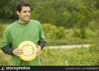 Close-up of a mid adult man holding a plastic disc