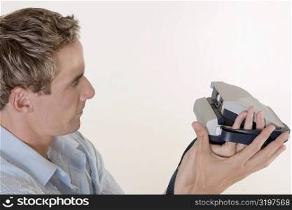 Close-up of a mid adult man holding an instant camera