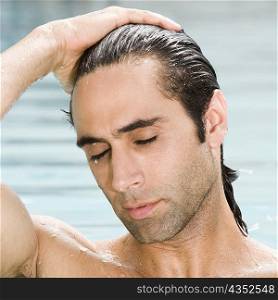 Close-up of a mid adult man in a swimming pool with his eyes closed