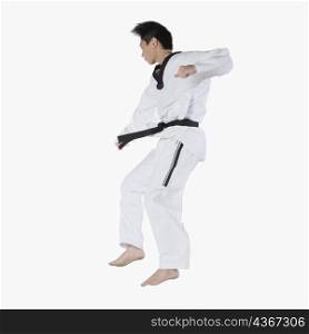 Close-up of a mid adult man jumping and practicing martial arts