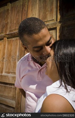 Close-up of a mid adult man kissing a young woman