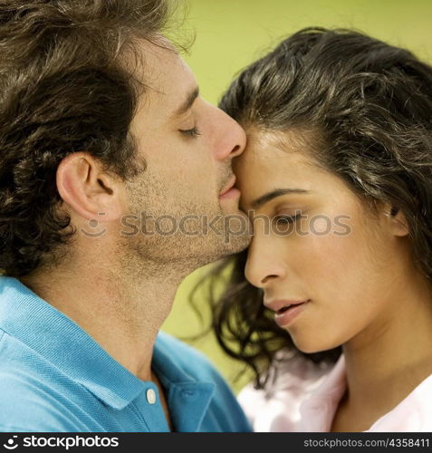 Close-up of a mid adult man kissing a young woman