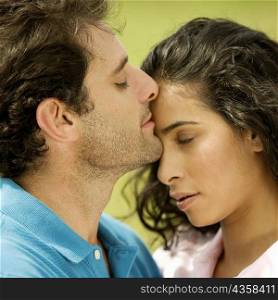 Close-up of a mid adult man kissing a young woman