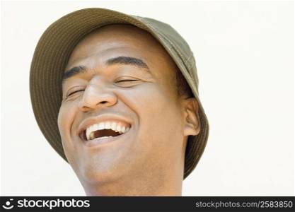 Close-up of a mid adult man laughing with his eyes closed