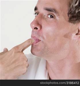 Close-up of a mid adult man licking his finger