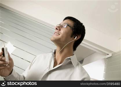 Close-up of a mid adult man listening to an MP3 Player