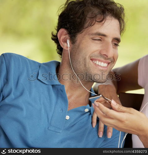 Close-up of a mid adult man listening to an MP3 player