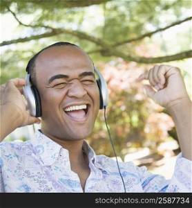Close-up of a mid adult man listening to music with headphones