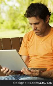 Close-up of a mid adult man looking at a laptop