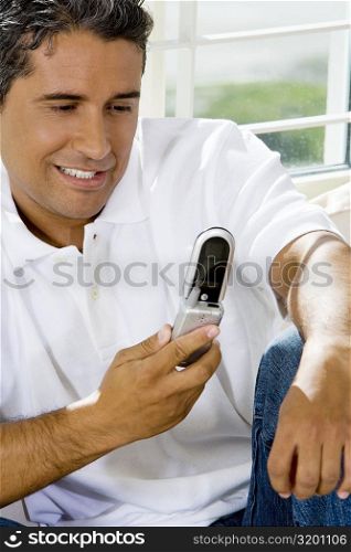 Close-up of a mid adult man looking at a mobile phone