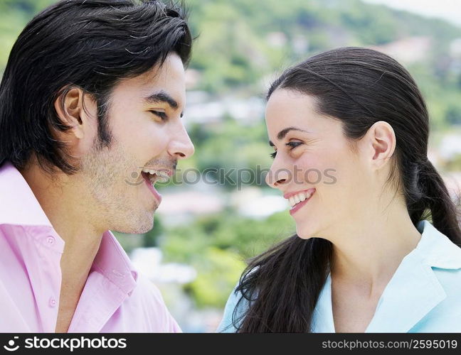 Close-up of a mid adult man looking at a young woman and smiling