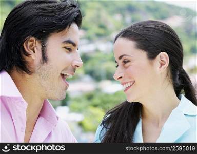 Close-up of a mid adult man looking at a young woman and smiling