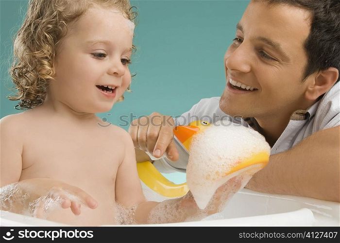 Close-up of a mid adult man looking at his daughter and smiling