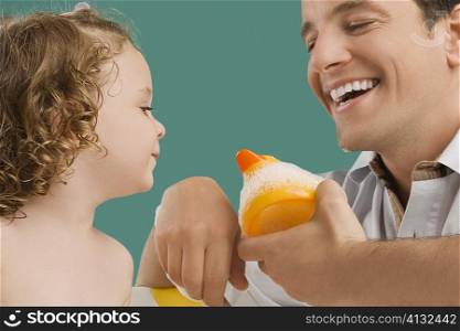 Close-up of a mid adult man looking at his daughter and smiling