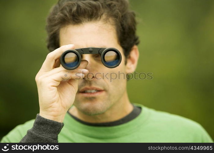 Close-up of a mid adult man looking through a pair of binoculars