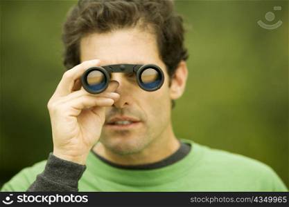Close-up of a mid adult man looking through a pair of binoculars
