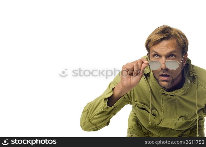 Close-up of a mid adult man peeking over his sunglasses