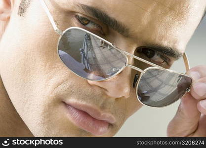 Close-up of a mid adult man peeking over his sunglasses