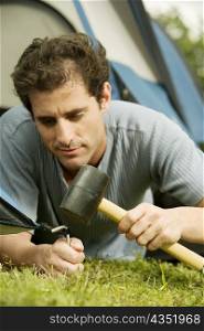 Close-up of a mid adult man pitching a tent