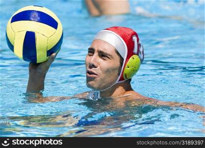 Close-up of a mid adult man playing water polo in a swimming pool