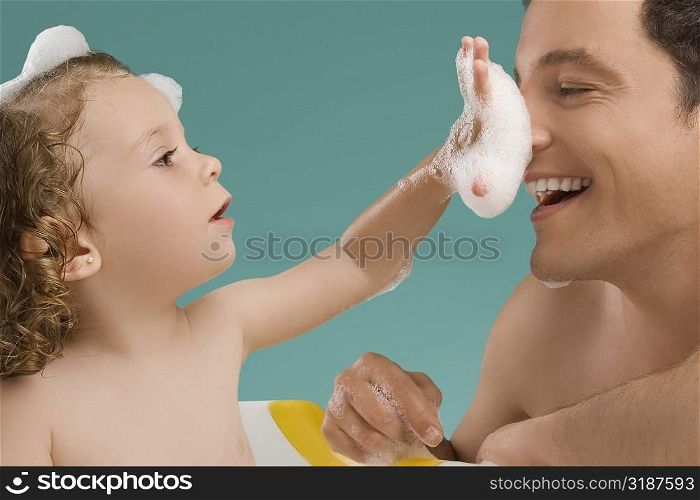 Close-up of a mid adult man playing with his daughter
