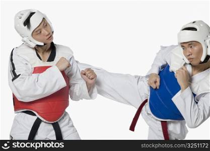 Close-up of a mid adult man practicing kickboxing with a young man