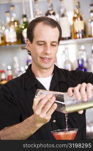 Close-up of a mid adult man preparing a cocktail