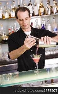 Close-up of a mid adult man preparing a cocktail