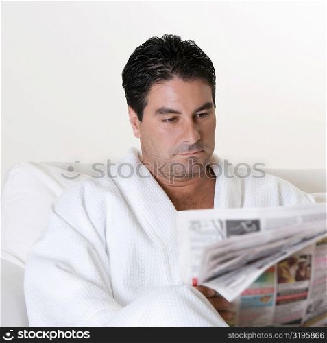 Close-up of a mid adult man reading a newspaper
