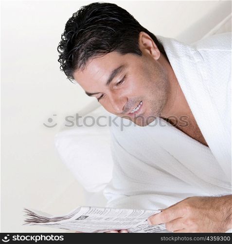Close-up of a mid adult man reading a newspaper
