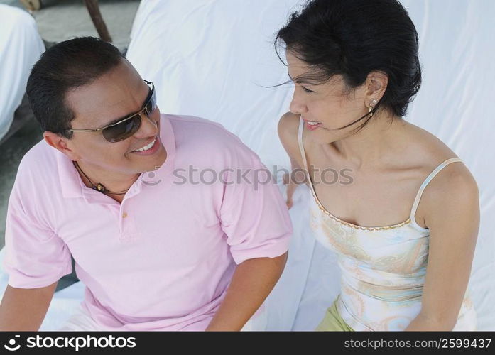 Close-up of a mid adult man sitting and smiling with a young woman