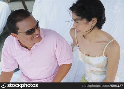 Close-up of a mid adult man sitting and smiling with a young woman
