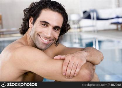 Close-up of a mid adult man sitting at the poolside