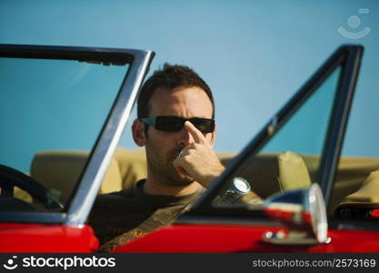 Close-up of a mid adult man sitting in a convertible car, Miami, Florida, USA