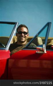 Close-up of a mid adult man sitting in a convertible car, Miami, Florida, USA
