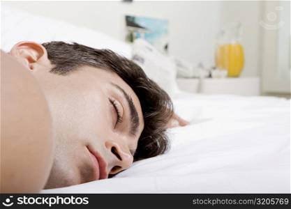 Close-up of a mid adult man sleeping on a bed